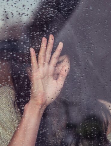 woman touch rainy glass